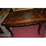 An early 20th century Belgian walnut parquet topped draw leaf dining table, raised on acanthus