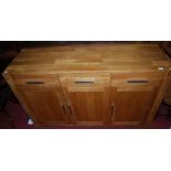 A contemporary light oak three door sideboard, having conforming upper drawers, width 130cm