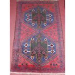 A small Persian woollen red ground rug, 135x80cm