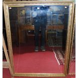 A reproduction gilt framed and bevelled rectangular wall mirror, 131 x 100cm