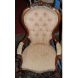 A mid-Victorian floral carved walnut and buttoned floral upholstered gentleman's open armchair,