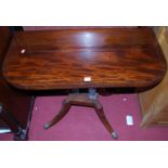 An early 19th century mahogany round cornered fold-over card table, having a revolving action raised