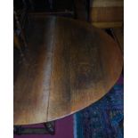 A heavy joined and moulded oak drop-leaf dining table, having a gateleg action on turned and