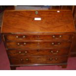 An early 19th century mahogany slope front writing bureau, enclosing a drawer lined and open