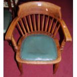 A 1930s oak tub stickback desk chair, having a green vinyl studded fixed pad seat on turned