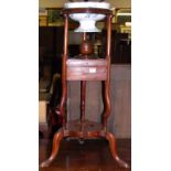 A 19th century mahogany circular three-tier wash stand, having ceramic bowl inset over two central