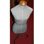 A mid-20th century tailor's dummy, on military green painted tubular metal stand, labelled Singer,