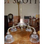 An early 20th century copper and brass hanging four branch ceiling light, having holophane type wavy