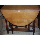 A 1930s oak drop-leaf dining table, having a gatleg action