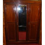 An Edwardian mahogany, satinwood crossbanded and further strung three door wardrobe, having bevelled