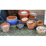 A collection of various terracotta and stoneware plant pots