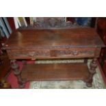 A circa 1900 heavily carved oak ledgeback two drawer side table, raised on bulbous knopped and
