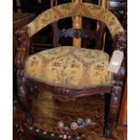 A late 19th century heavily carved oak and floral upholstered tub desk chair, having lion mask