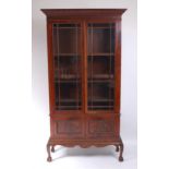 A circa 1900 mahogany bookcase on stand, the upper section having acanthus carved cornice and