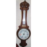 An early 20th century floral carved oak two dial aneroid wheel barometer, with engraved brass plaque