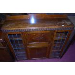 A 1930s oak ledgeback combination bureau bookcase, having fall-front compartment over panelled lower