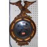 A 19th century small circular gilt wood convex mirror, having carved eagle surmount, height 39cm