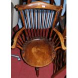 An early 20th century beech stick back elbow chair having a dished seat