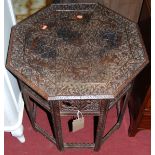 A circa 1900 Indian heavily relief carved teak octagonal occasional table (with some losses to
