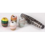 A selection of five assorted cylindrical glass beads, to include one black and grey bead with