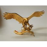 A large gold painted porcelain model of an American eagle, with outstretched wings and perched on