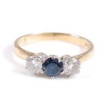 An 18ct yellow and white gold, sapphire and diamond three-stone ring, the centre round sapphire