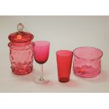 A cranberry glass jar and cover together with matching bowl and cranberry glass beaker and wine