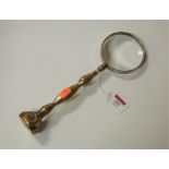 A large magnifying glass with engraved silver plated handle