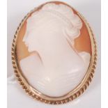 A 9ct yellow gold oval shell cameo brooch depicting a Roman woman, with ropetwist surround and