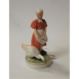 A Royal Copenhagen porcelain figure of a young girl with goose at her feet, having printed mark