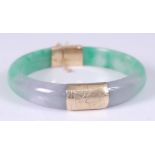 A dyed jadeite hinged circular bangle, with 14ct yellow gold hinged and engraved box clasp and