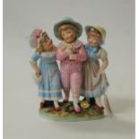 An early 20th century continental porcelain figure group of three children, each in standing pose,