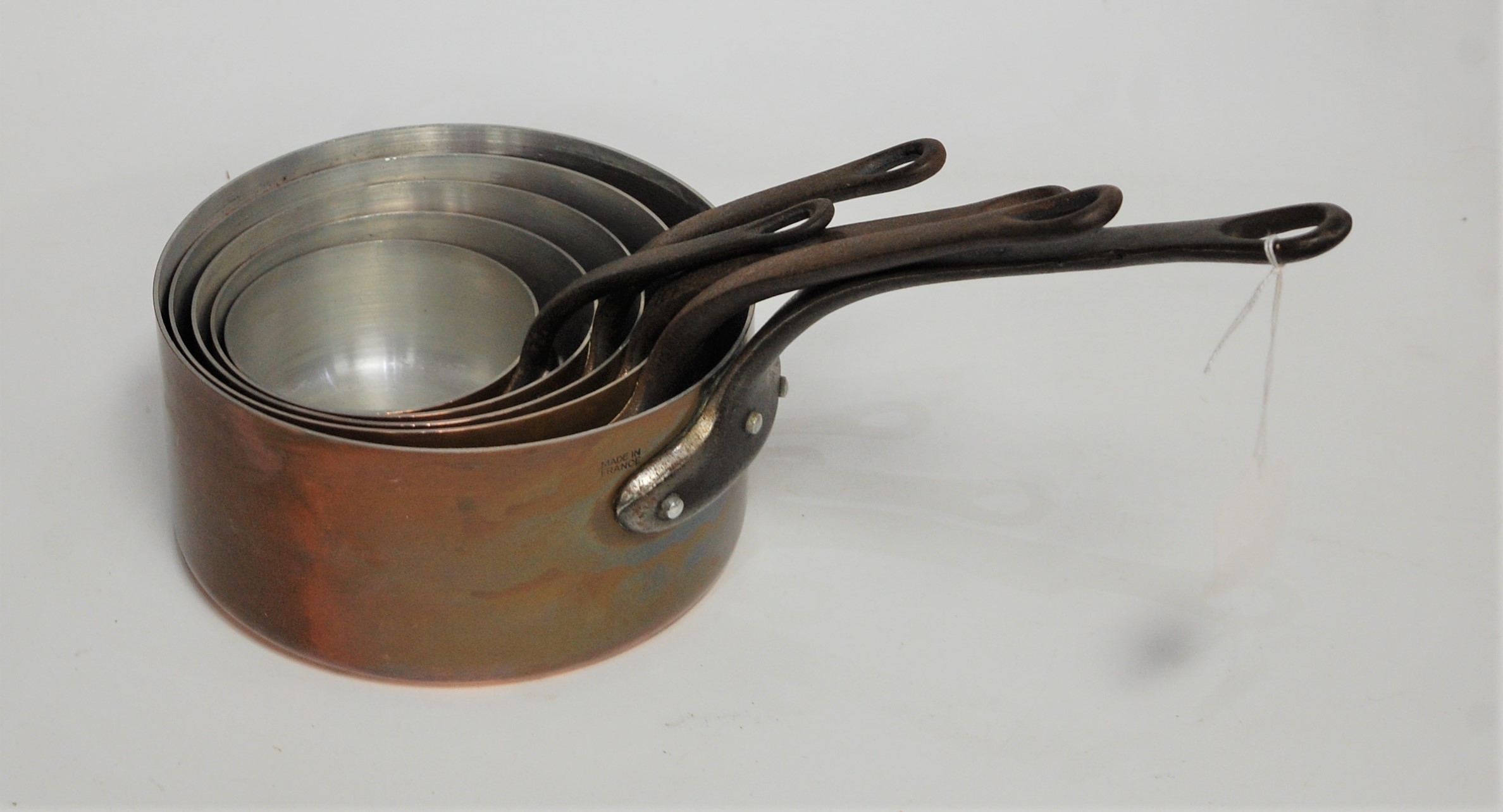A graduated set of five copper saucepans, each with iron handle, dia. of largest 18cm