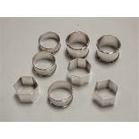 A set of three George V silver napkin rings of plain hexagonal form together with various other