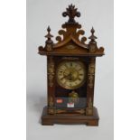 A late 19th century continental walnut cased mantel clock, having enamelled chapter ring, with Roman