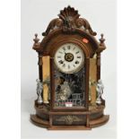 A late 19th century walnut cased mantel clock, the paper dial with Roman numerals, having eight