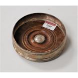 A modern silver bottle coaster, of squat circular form, with mahogany base, dia. 13cm