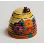 A Clarice Cliff preserve pot and cover, in the Gay Day pattern, the cover surmounted by a bee (