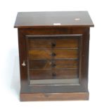 A mid 20th century stained pine collectors cabinet, the glazed door enclosing six blue velvet