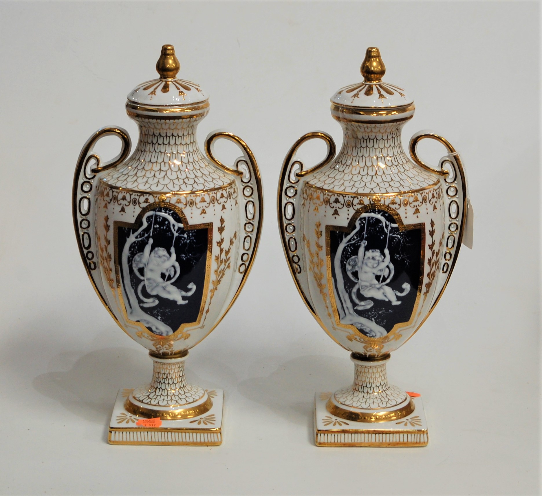 A pair of modern twin handled vases and covers, each of baluster form, each panel having pâte-sur-