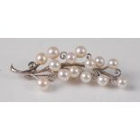 A white metal pearl set floral spray brooch, the brooch having fourteen 5.7 - 5.9mm cultured Akoya