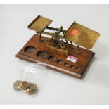 A pair of Victorian brass postal scales and weights on an oak plinth