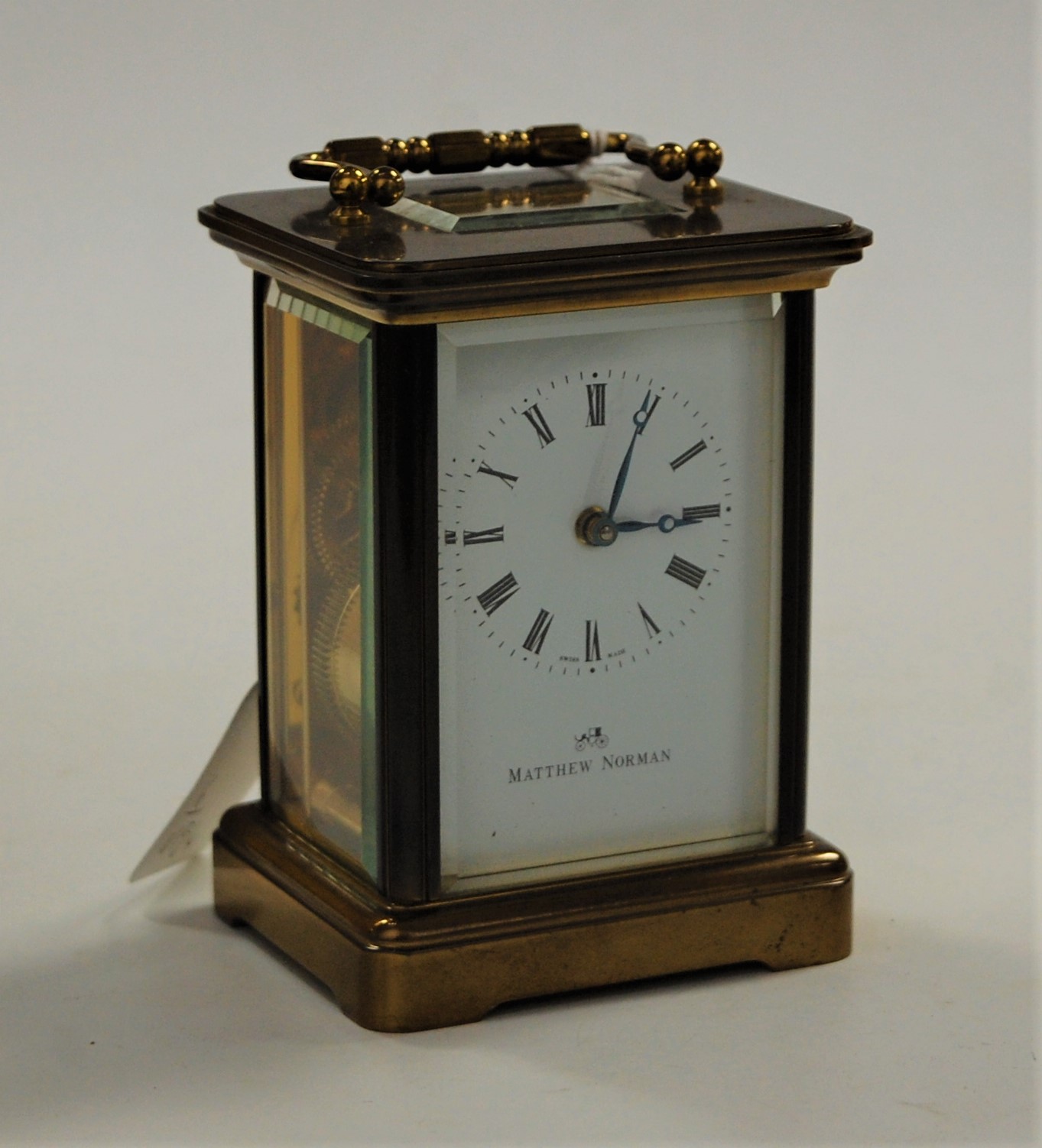 A mid-20th century lacquered brass cased carriage clock, the enamelled dial signed Matthew Norman,