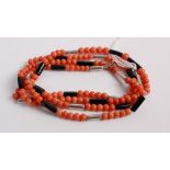 A beaded coral, black onyx and white metal long necklace, 94cm
