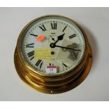 A Sestrel brass cased ships bulkhead clock having a circular enamel dial with Arabic numerals and