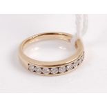 A modern 9ct gold diamond half eternity ring channel set with 9 small brilliants, stated total carat