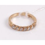 A contemporary 9ct gold diamond half eternity ring, the seven brilliants in a half open rub over