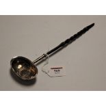 A George III white metal toddy ladle, inset with a 1787 sixpence, on a turned whalebone handle