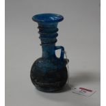 A Roman? blue glass vase having a flared rim over handle trailing round the slender neck having a