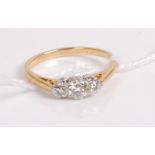 A yellow metal diamond three stone ring, the centre round cut diamond weighing approx 0.2 carats,